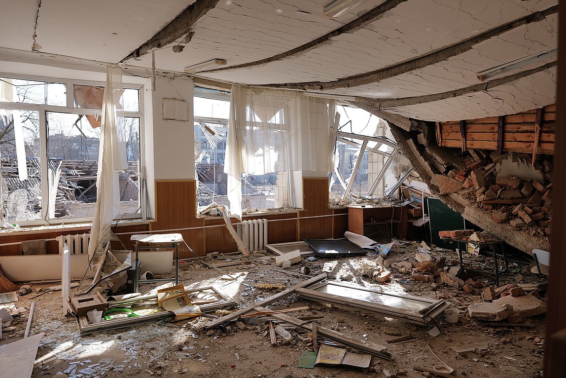 Ein zerstörtes Klassenzimmer voller Schutt.