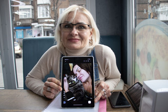 Eine Frau zeigt ein Foto von ihrer Tochter.