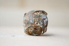 Die Submunition ist ein runder metallischer Ball, schmutzig und rostig.