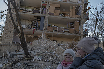 Zwei Frauen stehen vor einem zerstörten Wohnhaus in der ukrainischen Hauptstadt Kiew. 